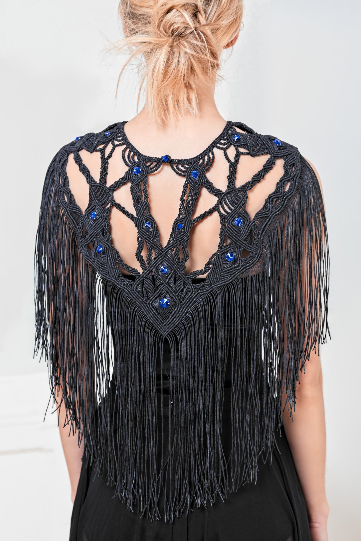 Close-up of the elegant fringes on the "Derinoe" macrame necklace. The long, flowing fringes made from high-quality cotton create a dynamic, aesthetic effect. The crystal glass stones add a subtle shine.
Detailaufnahme der eleganten Fransen der "Derinoe" Makramee Halskette. Die langen Fransen aus hochwertiger Baumwolle fallen fließend und sorgen für einen dynamischen, ästhetischen Effekt. Die Kristallglassteine setzen einen dezenten Glanz.